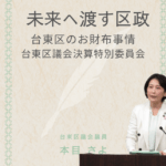 台東区議会議員の本目さよが、決算特別委員会で財政運営について質問している様子。 画像上部には「未来へ渡す区政　台東区のお財布事情　台東区議会決算特別委員会」と書かれている。